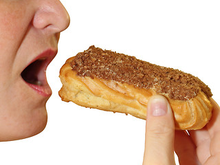 Image showing Close up of a young woman eating a cake eclair over white background.