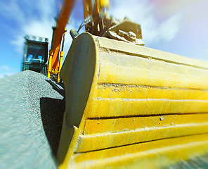 Image showing excavator against blue sky. Toned image. Motion blur effect.