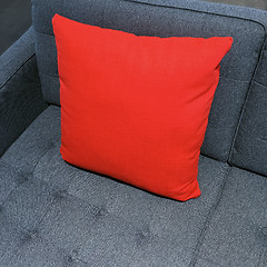 Image showing Vibrant red cushion decorating gray sofa