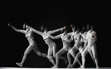 Image showing Full-length portrait of woman wearing white fencing costume on black