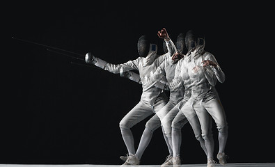 Image showing Full-length portrait of woman wearing white fencing costume on black