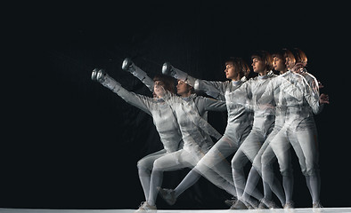 Image showing Full-length portrait of woman wearing white fencing costume on black