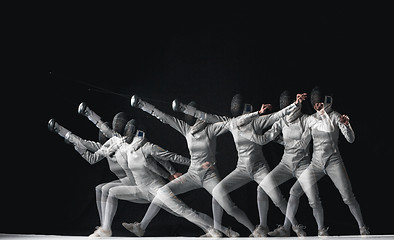 Image showing Full-length portrait of woman wearing white fencing costume on black