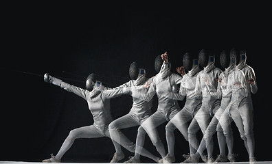 Image showing Full-length portrait of woman wearing white fencing costume on black