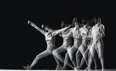 Image showing Full-length portrait of woman wearing white fencing costume on black