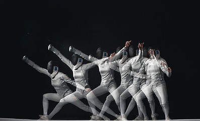 Image showing Full-length portrait of woman wearing white fencing costume on black