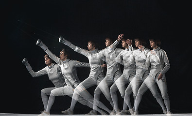 Image showing Full-length portrait of woman wearing white fencing costume on black