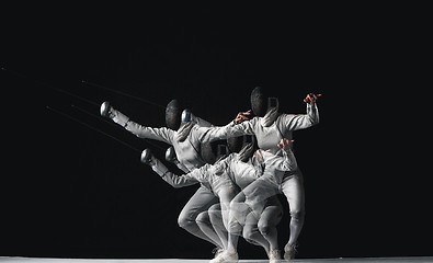 Image showing Full-length portrait of woman wearing white fencing costume on black