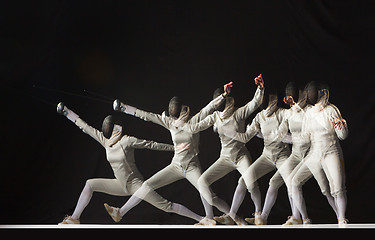 Image showing Full-length portrait of woman wearing white fencing costume on black