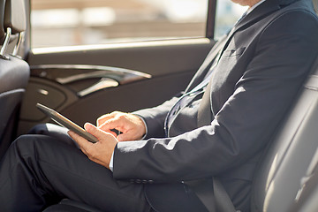 Image showing senior businessman with tablet pc driving in car