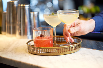 Image showing bartender with glasses of cocktails at bar