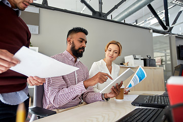 Image showing business team with tablet pc and papers in office