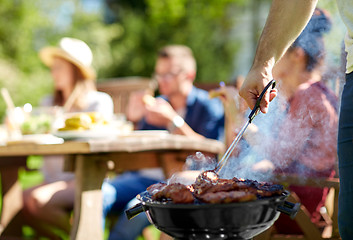 Image showing man cooking meat on barbecue grill at summer party