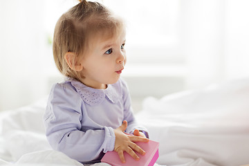 Image showing happy little baby girl with gift box at home