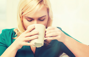 Image showing happy woman  with cup of tea or coffee at home