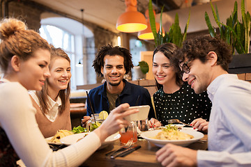 Image showing friends with smartphone eating at restaurant