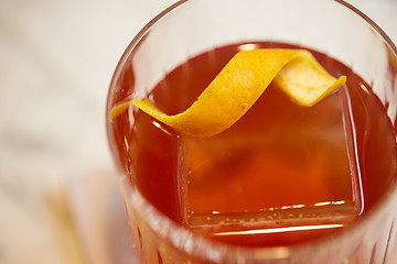 Image showing close up of glass with orange cocktail at bar