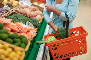 Image showing woman with basket buying broccoli at grocery store