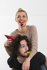 Image showing couple in party hats blowing in whistle