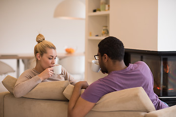 Image showing Young multiethnic couple  in front of fireplace