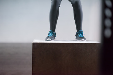 Image showing black woman is performing box jumps at gym