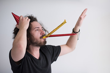 Image showing Portrait of a man in party hat blowing in whistle