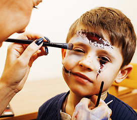 Image showing little cute child making facepaint on birthday party, zombie Apo