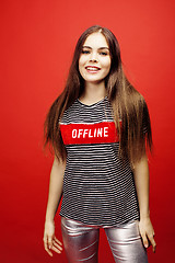 Image showing young pretty emitonal posing teenage girl on bright red background, happy smiling lifestyle people concept