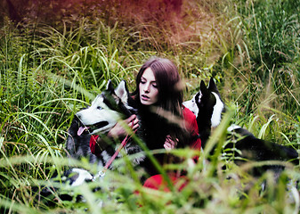 Image showing woman in red dress with tree wolfs, forest, husky dogs mystery p