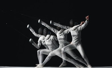 Image showing Full-length portrait of woman wearing white fencing costume on black