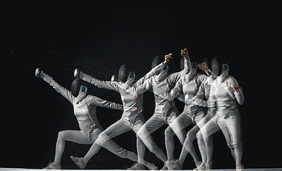 Image showing Full-length portrait of woman wearing white fencing costume on black