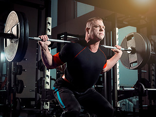 Image showing Portrait of super fit muscular young man working out in gym with barbell