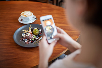 Image showing woman with smartphone photographing food at cafe