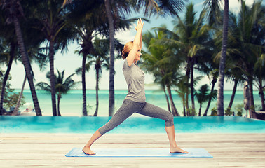 Image showing woman making yoga warrior pose on mat