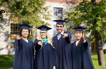 Image showing happy students or bachelors pointing finger at you