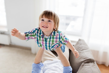 Image showing father hands holding happy little boy at home