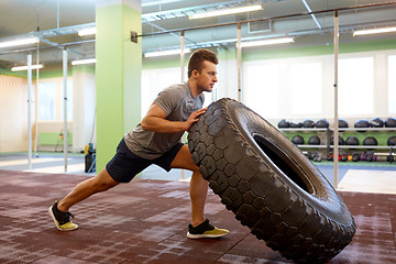 Image showing man doing strongman tire flip training in gym