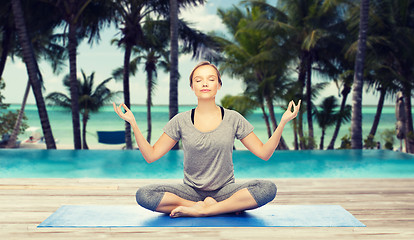 Image showing woman making yoga meditation in lotus pose on mat