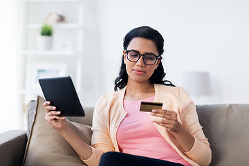 Image showing happy woman with tablet pc and credit card at home