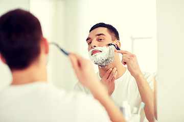 Image showing man shaving beard with razor blade at bathroom