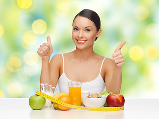 Image showing woman with food and measure tape showing thumbs up