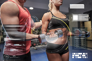 Image showing young couple with dumbbell flexing muscles in gym