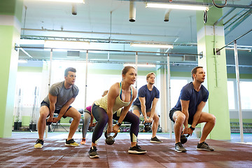 Image showing group of people with kettlebells exercising in gym