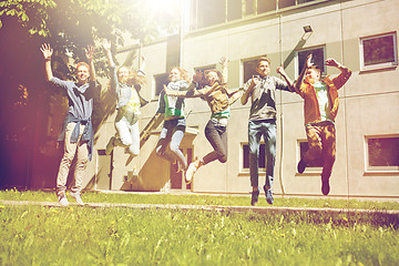 Image showing happy teenage students or friends jumping outdoors