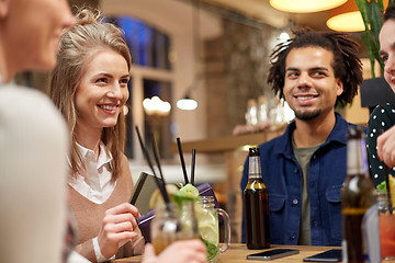 Image showing friends with drinks, credit card and bill at bar