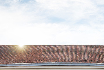 Image showing cloudy blue sky and tiled roof top