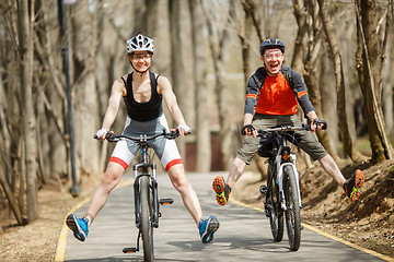 Image showing Funny bicyclists driving around park