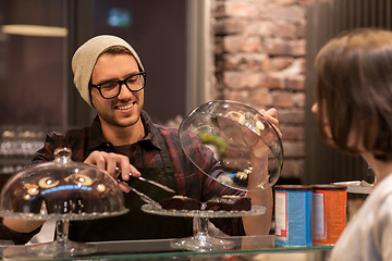 Image showing man or barman with cakes serving customer at cafe