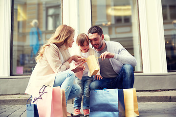 Image showing happy family with child and shopping bags in city