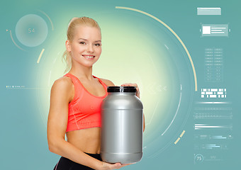 Image showing smiling sporty woman with sports nutrition jar